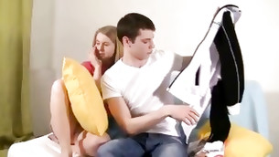 Lovely young straight couple is reading a magazine on the couch